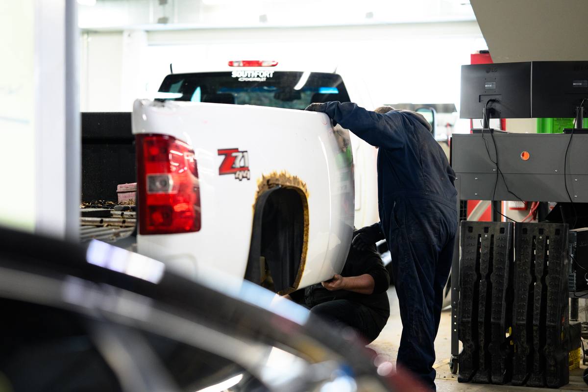 White pickup truck in a repair bay at Fix Auto Sherwood North